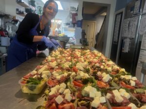 Student, Jaya photographed with some of East Brighton Food Co-op's fresh, healthy, nutritious meals, ready to be delivered across Brighton & Hove to those recently discharged form hospital